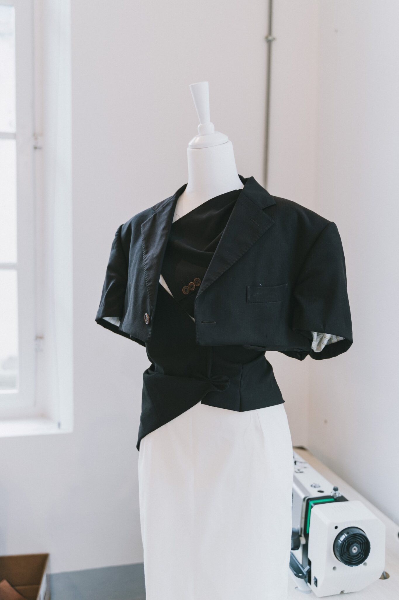 Chaqueta drapeada sobre un maniquí en el taller